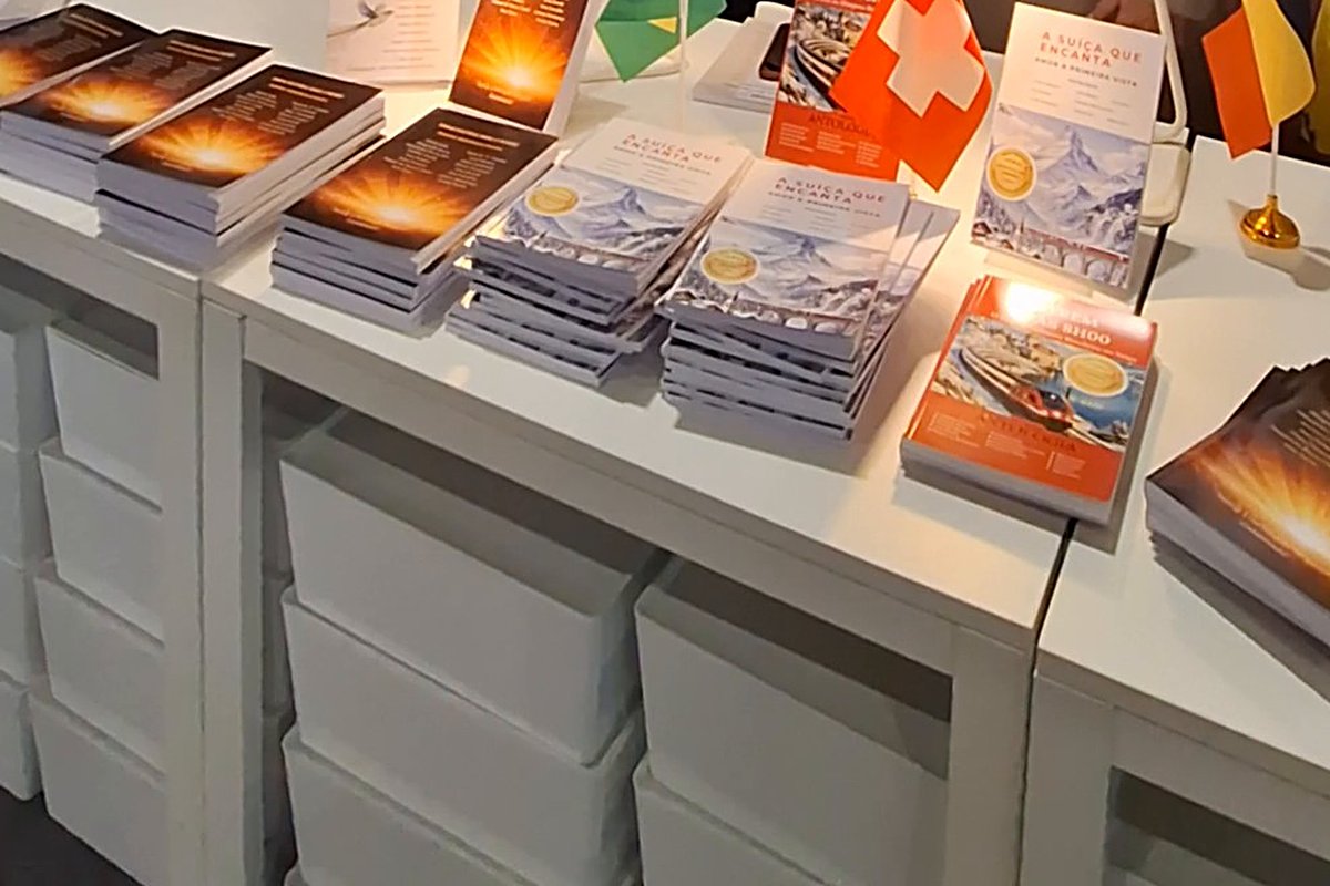 Mesa do estande E∞Linia Brandt com livros e bandeiras